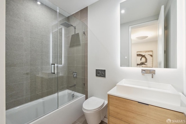 full bathroom featuring vanity, bath / shower combo with glass door, and toilet