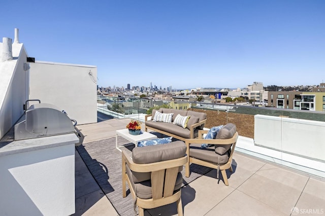 view of patio featuring a balcony, an outdoor hangout area, and exterior kitchen