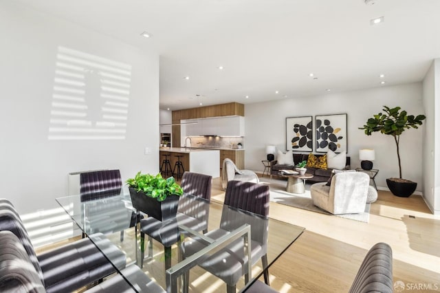 dining space featuring sink and light hardwood / wood-style flooring