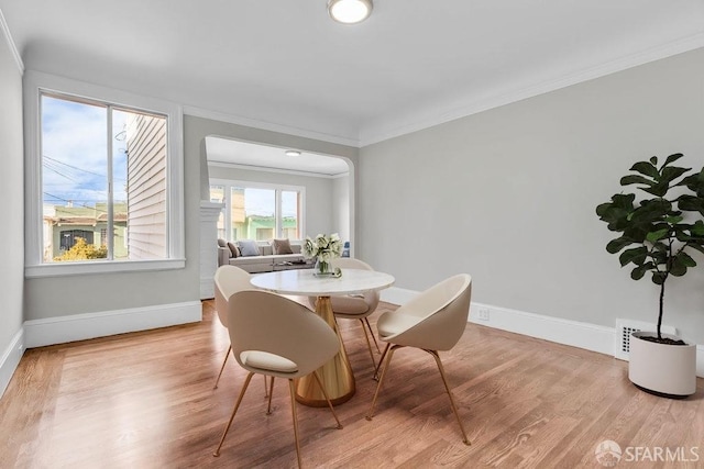 dining area featuring light hardwood / wood-style floors and crown molding