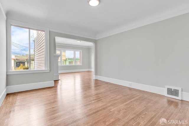 spare room featuring light hardwood / wood-style floors and crown molding