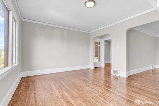 spare room with ornamental molding and light hardwood / wood-style flooring