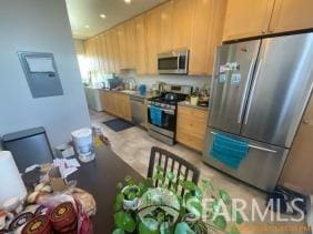 kitchen with light brown cabinetry and stainless steel appliances