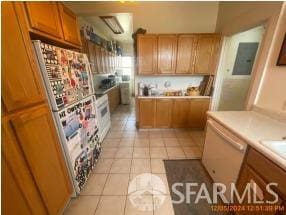 kitchen with white appliances, light tile patterned floors, and electric panel