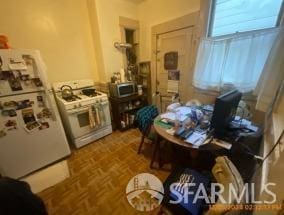 kitchen featuring white appliances and parquet flooring