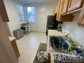 kitchen featuring sink and light tile patterned flooring