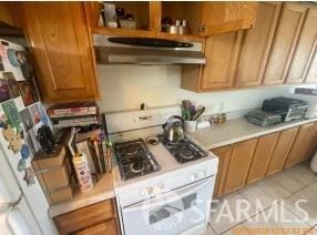 kitchen with light tile patterned flooring and white gas range