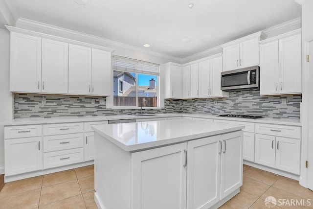 654 Tain Ct, Brentwood, CA 94513 - kitchen featuring stainless steel microwave, light tile patterned flooring, a center island, light countertops, and crown molding