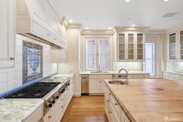 2000 Washington St Unit 4, San Francisco, CA 94109 - kitchen featuring a sink, backsplash, stainless steel gas cooktop, butcher block counters, and ornamental molding