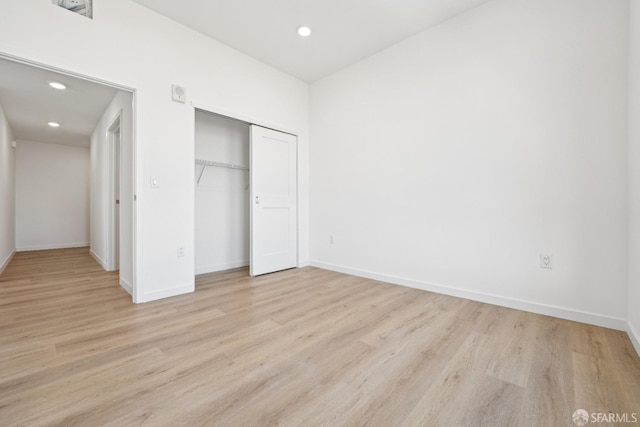 unfurnished bedroom with a closet and light hardwood / wood-style floors