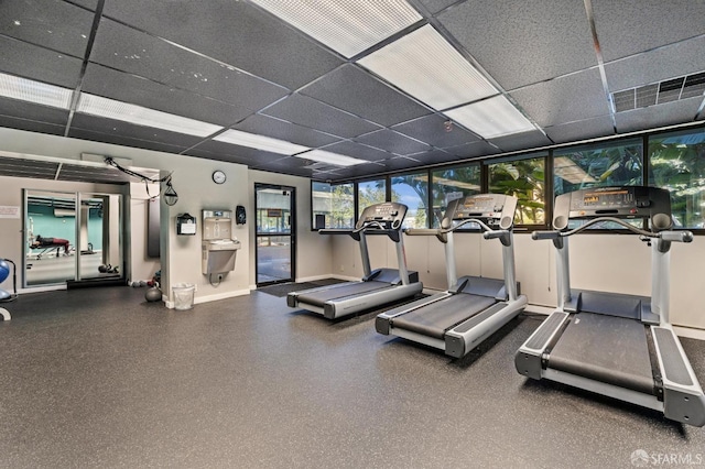 workout area featuring floor to ceiling windows and a paneled ceiling