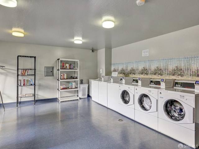 laundry area with a textured ceiling, washing machine and dryer, and electric panel