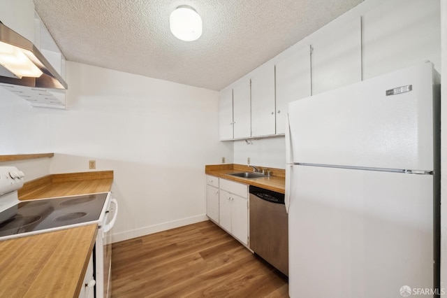 kitchen featuring white appliances, exhaust hood, light hardwood / wood-style floors, white cabinets, and sink