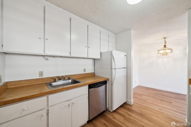 kitchen featuring sink, white cabinets, a textured ceiling, dishwasher, and pendant lighting