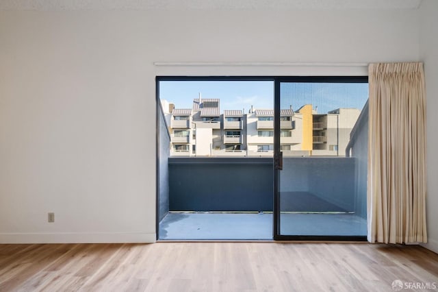 empty room featuring a textured ceiling, wood-type flooring, and a wealth of natural light