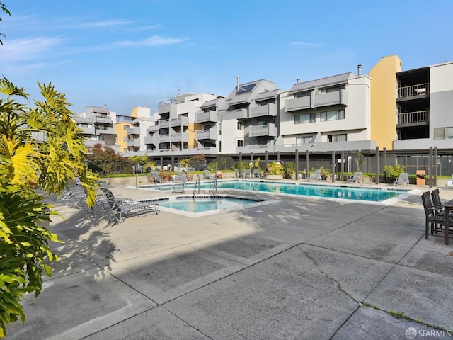 view of pool with a patio area and a hot tub