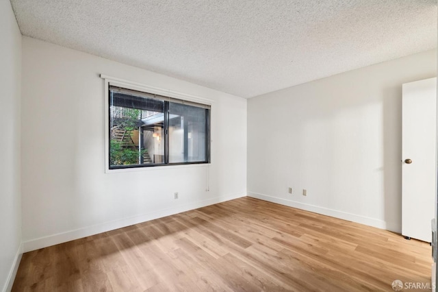 empty room featuring a textured ceiling and light wood-type flooring