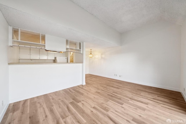 unfurnished living room featuring a textured ceiling and light wood-type flooring