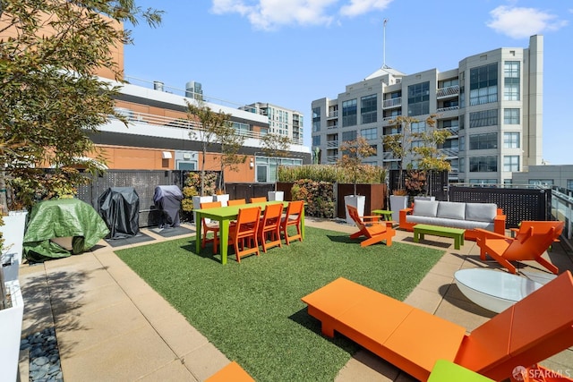 view of community featuring an outdoor living space, a patio area, and a yard