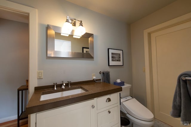 bathroom with hardwood / wood-style floors, toilet, and vanity