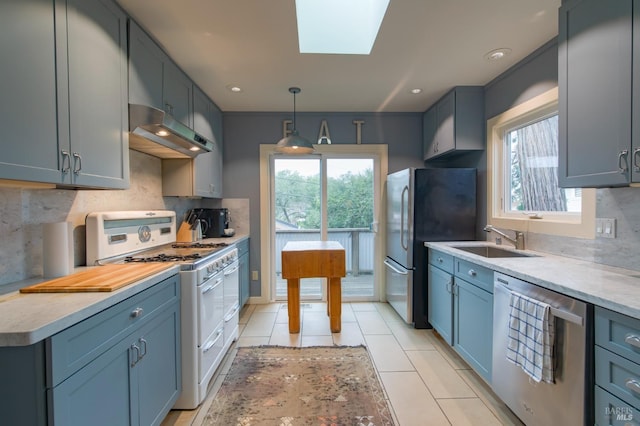 kitchen with tasteful backsplash, a skylight, sink, stainless steel appliances, and light tile patterned flooring