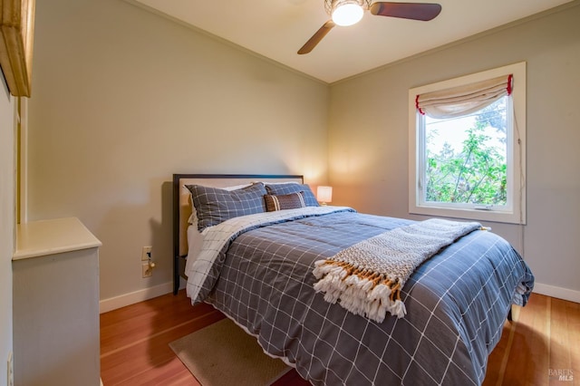 bedroom with wood-type flooring, ceiling fan, and ornamental molding