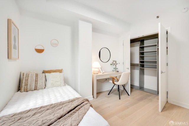 bedroom with light wood-type flooring and a closet