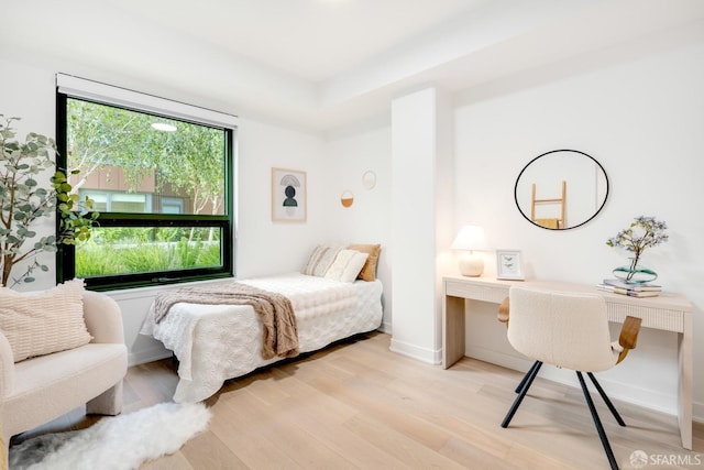 bedroom with built in desk and light hardwood / wood-style flooring