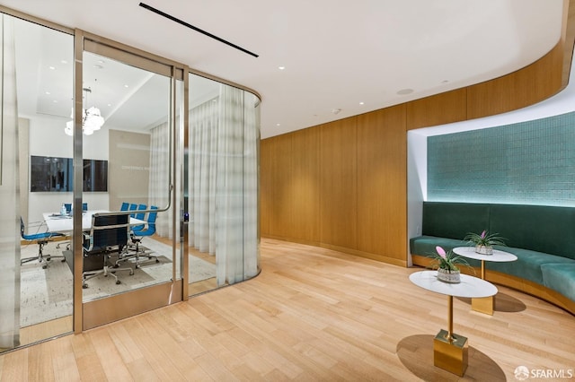 interior space with wooden walls and light hardwood / wood-style flooring