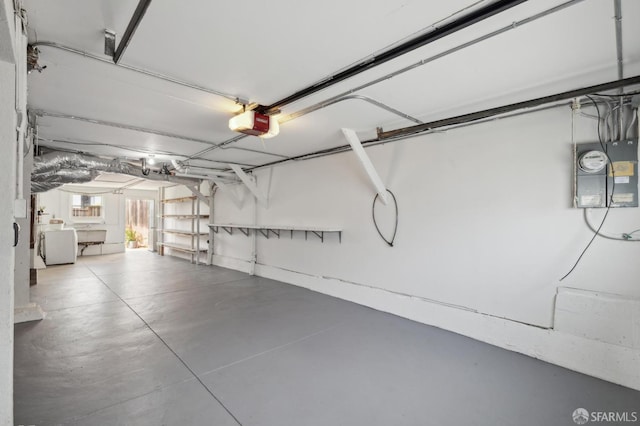 garage featuring a garage door opener, washer / clothes dryer, and sink