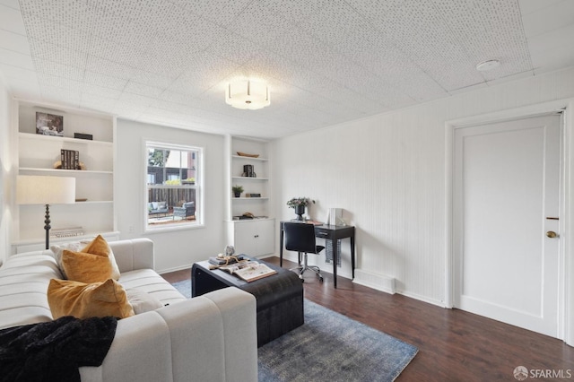 living room with dark wood-type flooring and built in features