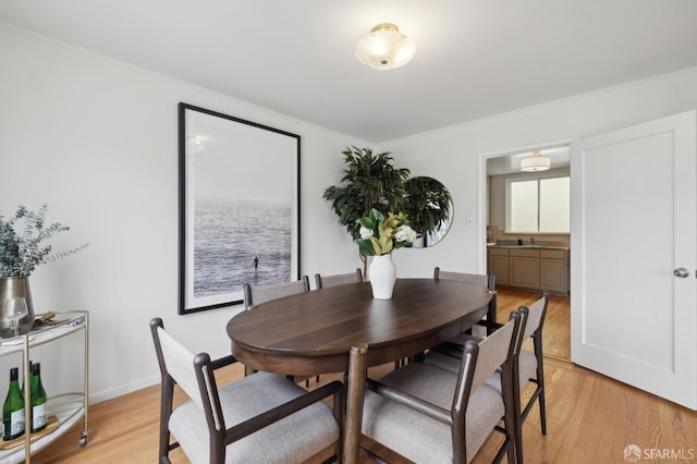 dining space featuring sink and light wood-type flooring