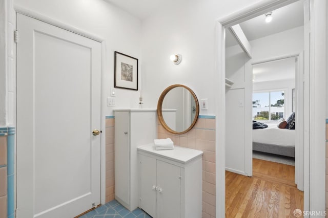 bathroom with tile walls and hardwood / wood-style flooring