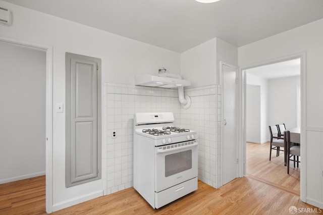 kitchen featuring white range with gas cooktop, light hardwood / wood-style flooring, and backsplash