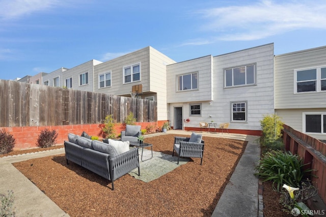 rear view of house featuring an outdoor living space and a patio area