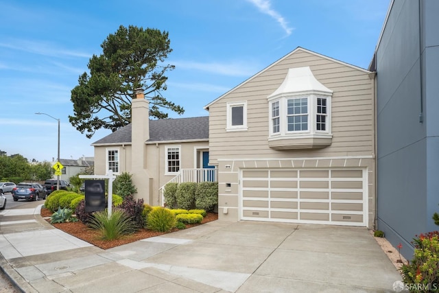 view of front of property with a garage, a chimney, a shingled roof, and driveway