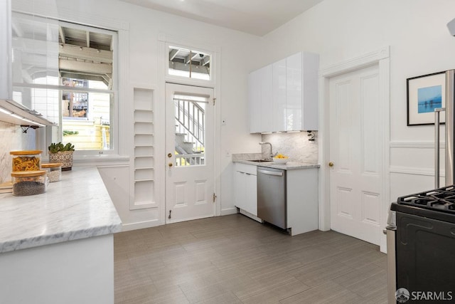 69 Pond St, San Francisco, CA 94114 - kitchen with dishwasher, black range with gas cooktop, white cabinetry, and tasteful backsplash