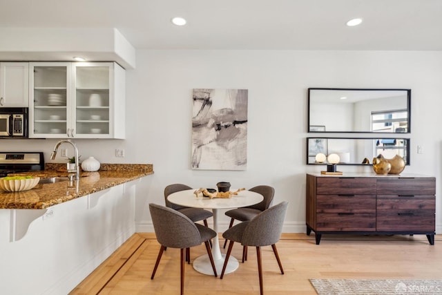 dining room featuring recessed lighting, baseboards, and light wood finished floors