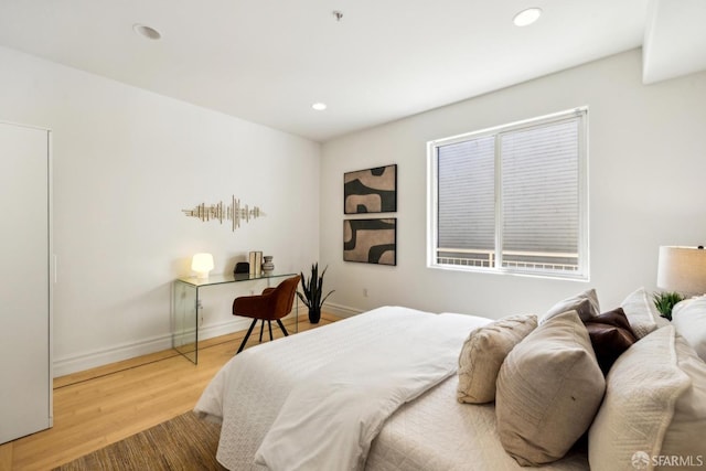 bedroom with recessed lighting, baseboards, and wood finished floors