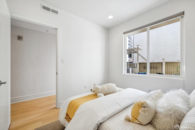 bedroom with baseboards, visible vents, wood finished floors, and recessed lighting