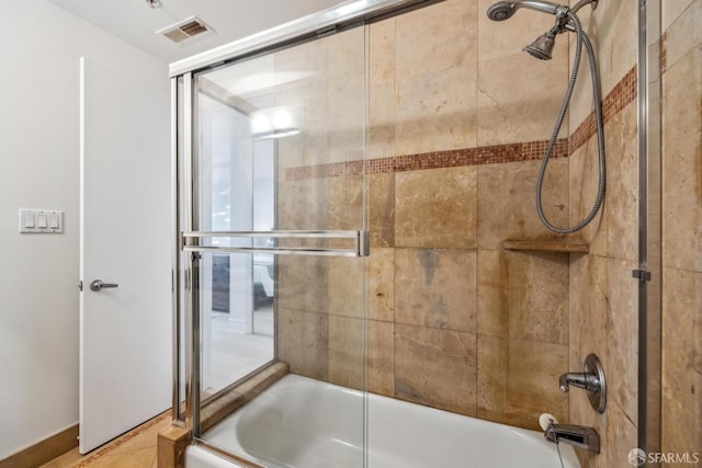 bathroom featuring visible vents and combined bath / shower with glass door