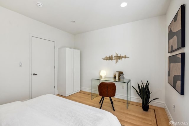 bedroom featuring light wood finished floors, recessed lighting, and baseboards