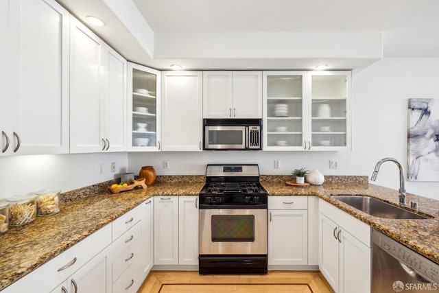 kitchen featuring appliances with stainless steel finishes, a sink, and white cabinets