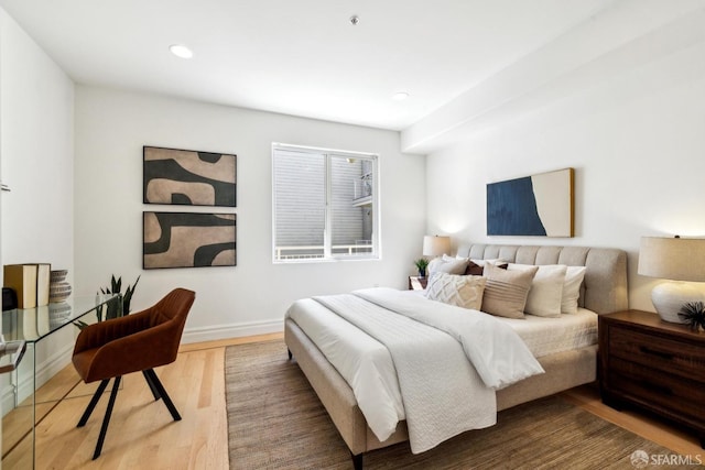 bedroom featuring baseboards, wood finished floors, and recessed lighting