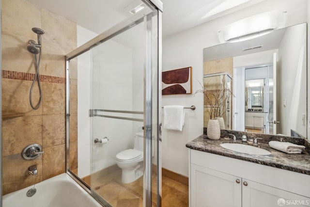 bathroom featuring enclosed tub / shower combo, toilet, and vanity