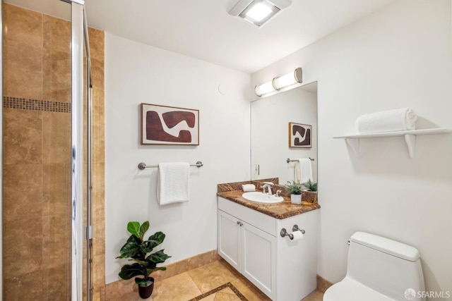 full bath featuring toilet, vanity, baseboards, a tile shower, and tile patterned floors