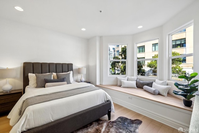 bedroom featuring recessed lighting, multiple windows, and wood finished floors