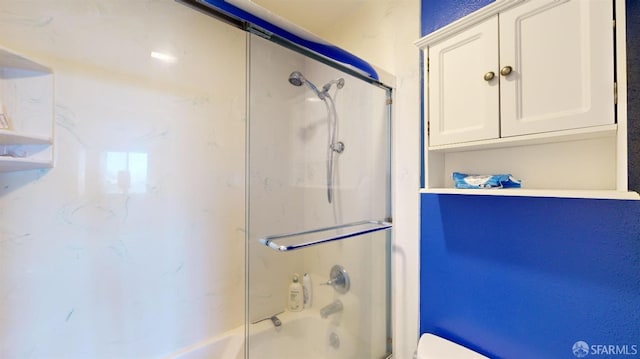 bathroom featuring enclosed tub / shower combo and toilet