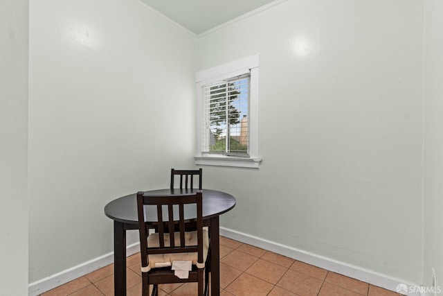 dining area with light tile patterned floors, baseboards, and crown molding