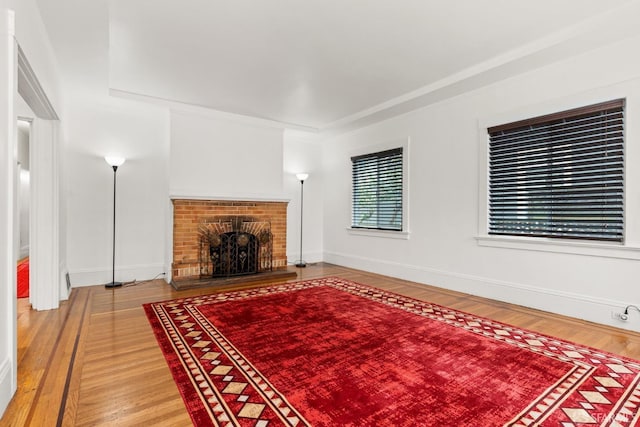 unfurnished living room featuring light wood finished floors, a fireplace, and baseboards